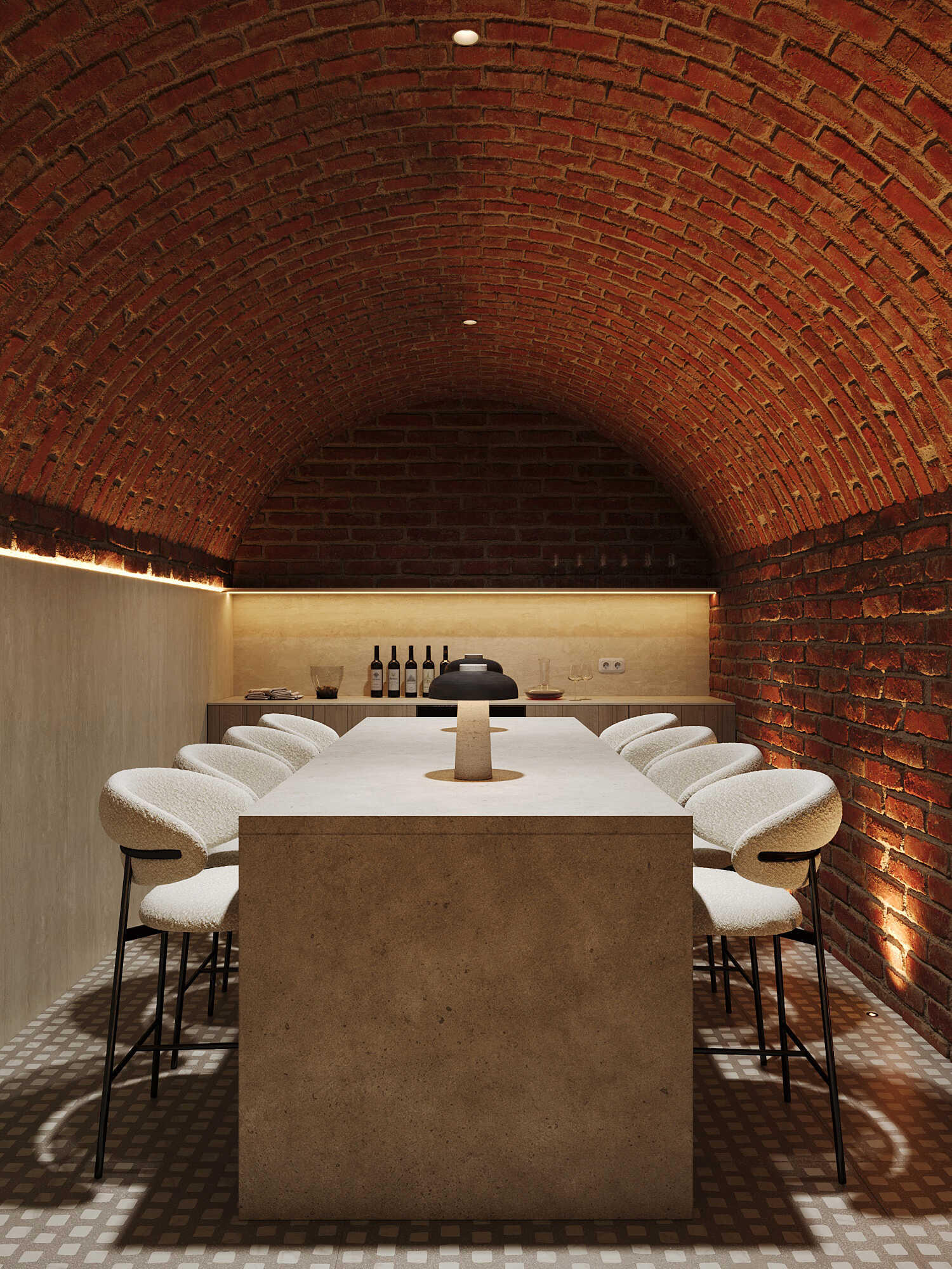 A vaulted brick wine cellar with a long stone table and bouclé chairs